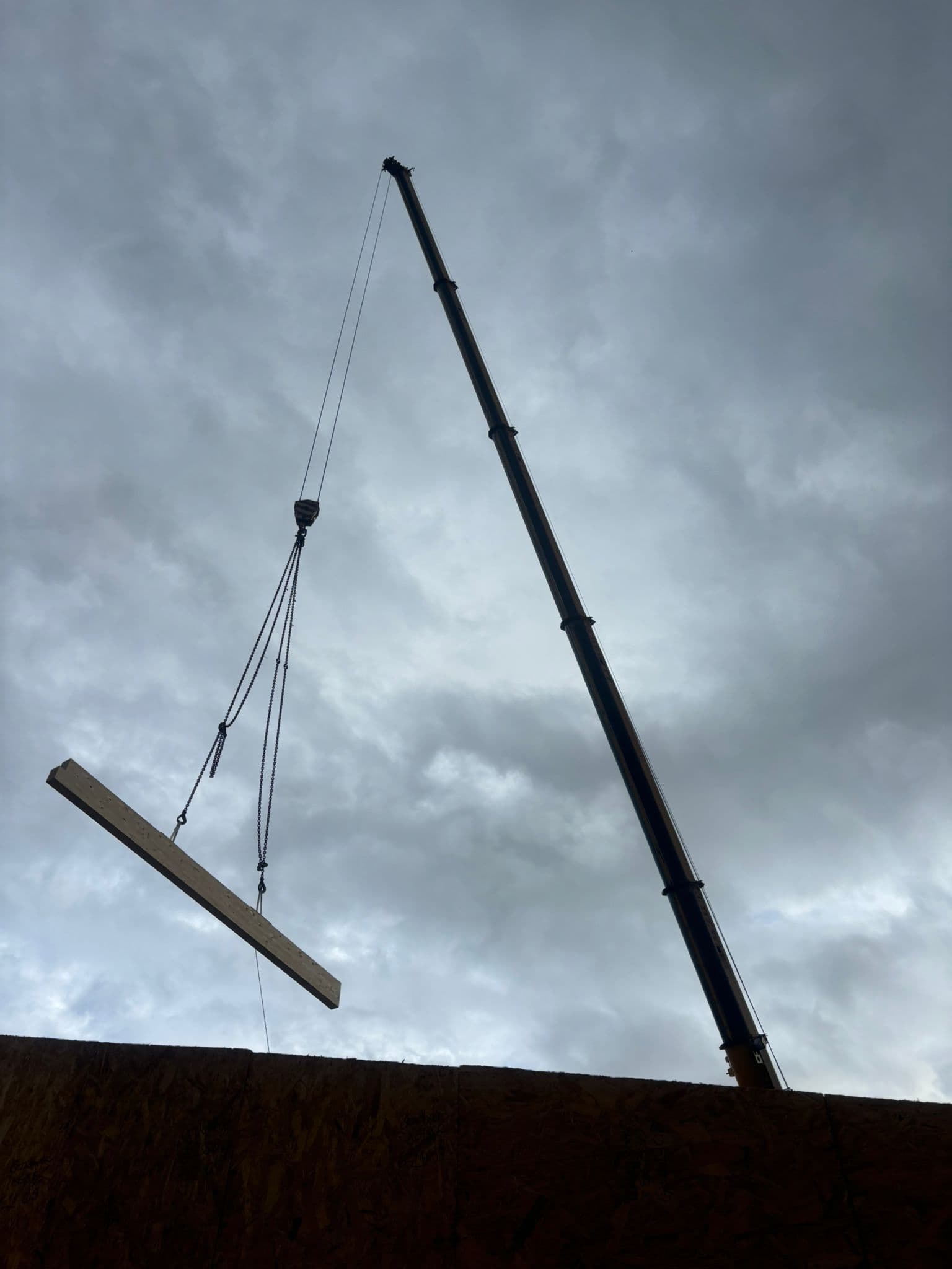 Crane lifting a timber beam into position
